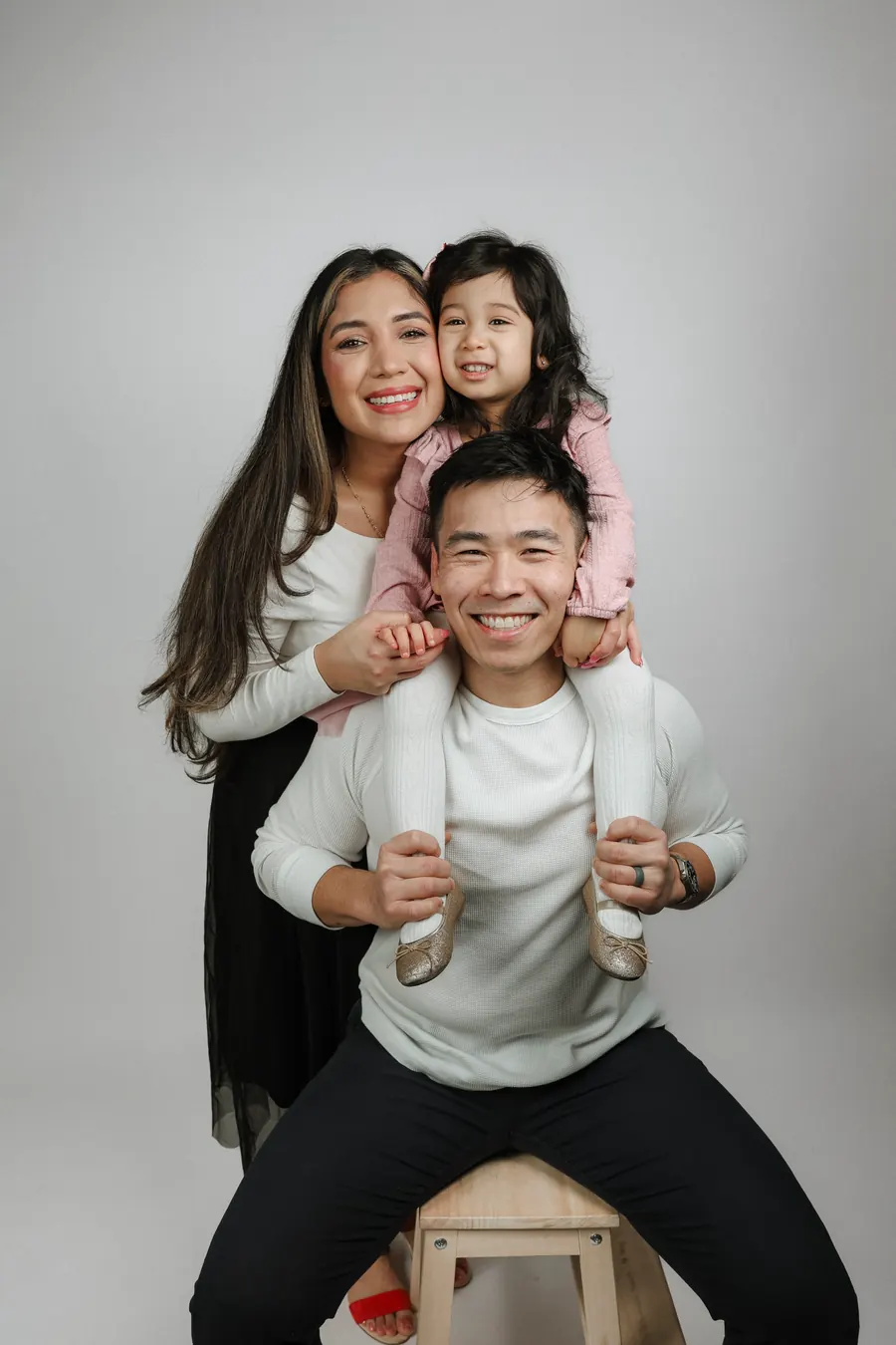 La Familia Hung: mamá, papá y su hija sonriendo
